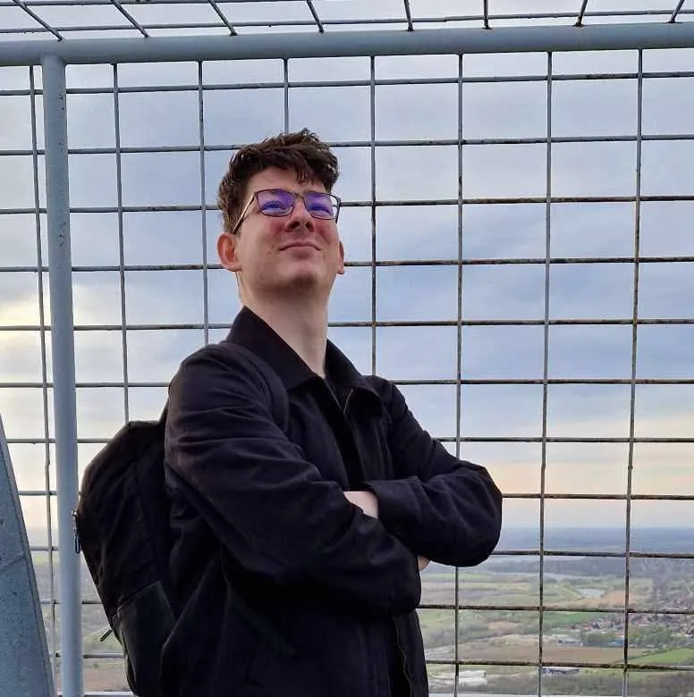 Veszprémi Dániel kitekint a magasból, a háttérben a táj
